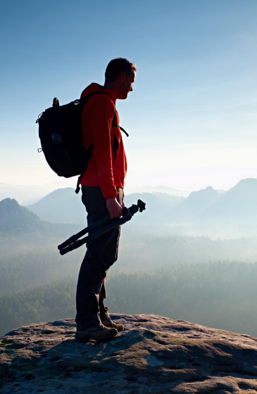 登山者站在山顶眺望远方，感受大自然的壮丽景色与自由。.